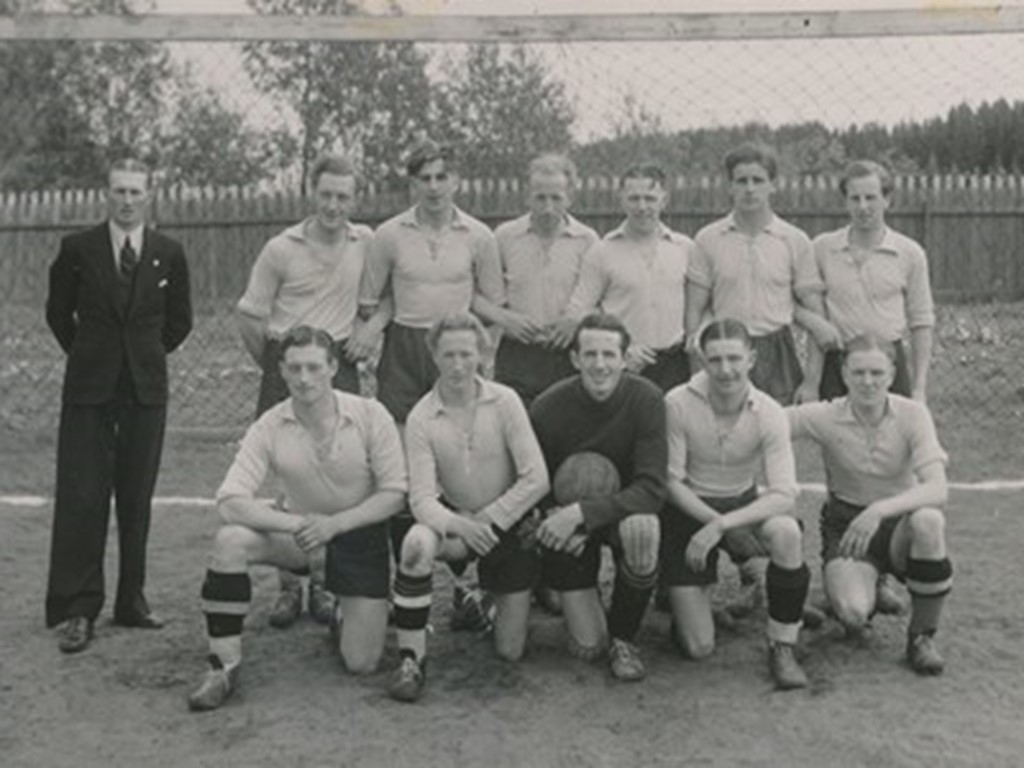 Alnö IF:s representationslag i Medelpadsserien 1946/1947. Stående fr v populäre lagledaren Almer Eriksson, Erik Bergström, Nils Eriksson, Allan Andersson, Folke Bymark, Ivar Östman och Gunnar Johansson. Knästående fr v Åke Schill, G Wedin, Sixten Bjurström, Kjell Pedersén och Sven Johansson. Foto: Alnö Hembygdsförening.. Bild: Alnö Hembygdsförening.