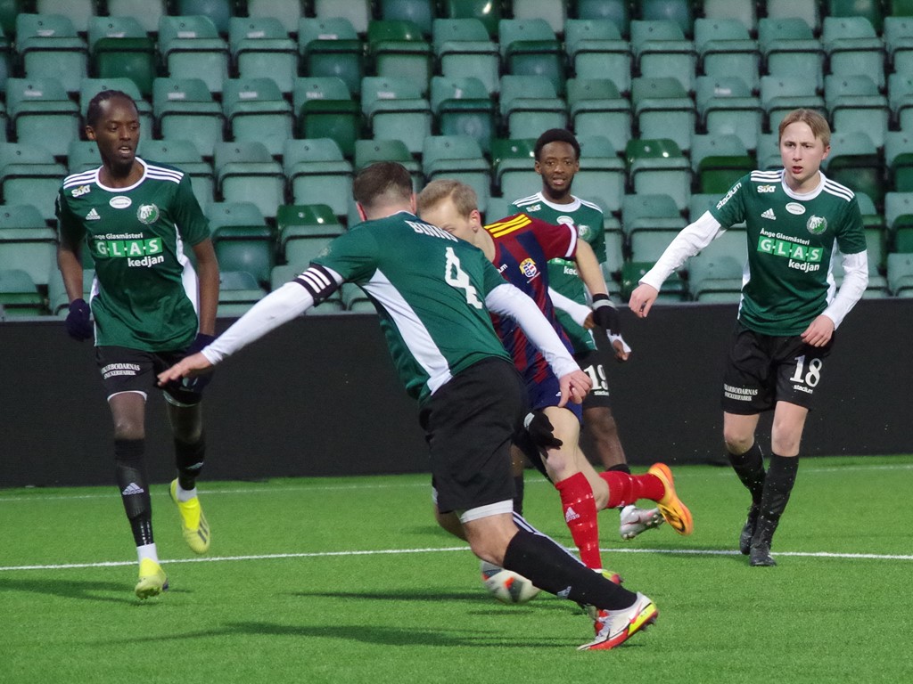 Selångers Melker Norén omringad av grönsvarta Östavallsspelare, fr v t h #3 Billy Gihuri. #4 Jordan Binns, #19 Jacob Gihuri och #18 Theo Evjen. Foto: Pia Skogman, Lokalfotbollen.nu.