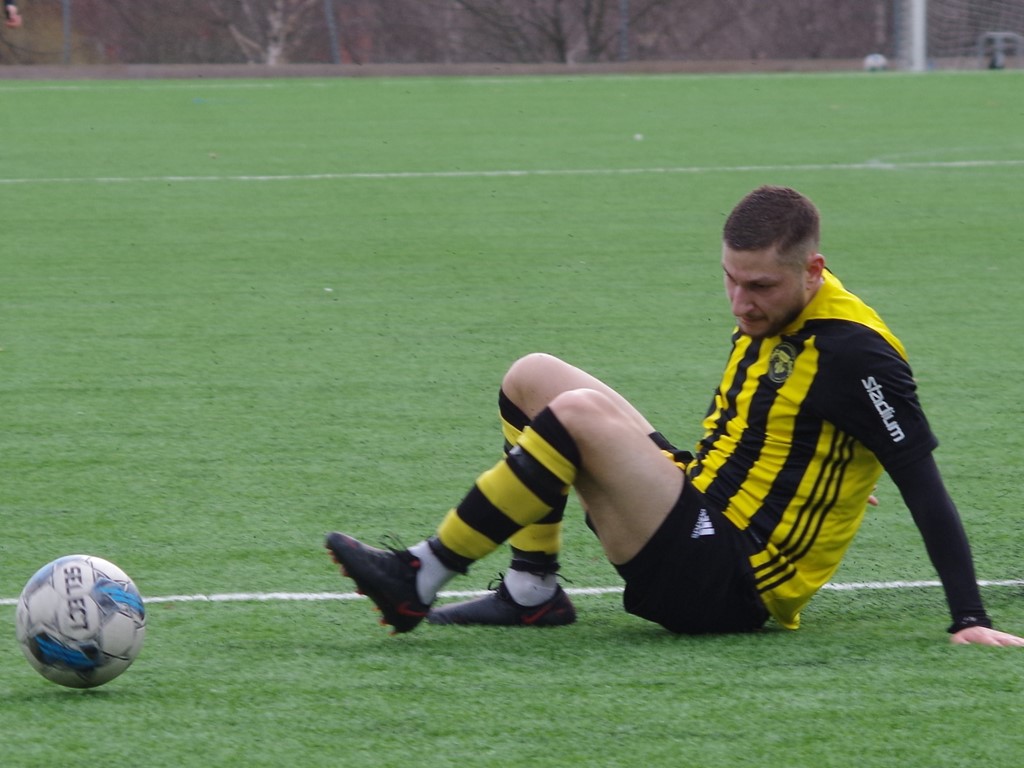 Ali Mahmoud lirar fotboll sittande. Foto: Pia Skogman, Lokalfotbollen.nu.