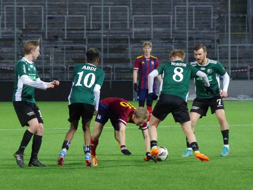 Melker Norén stoppas av Östavalls försvar, fr v #18 18. Theo Evjen, #10 Asad Abdi Mohamed Nur, #8 Wiking Nordin och #7 Lukas Vikberg,. Pontus Lundqvist håller sig i bakgrunden. Foto: Pia Skogman, Lokalfotbollen.nu.